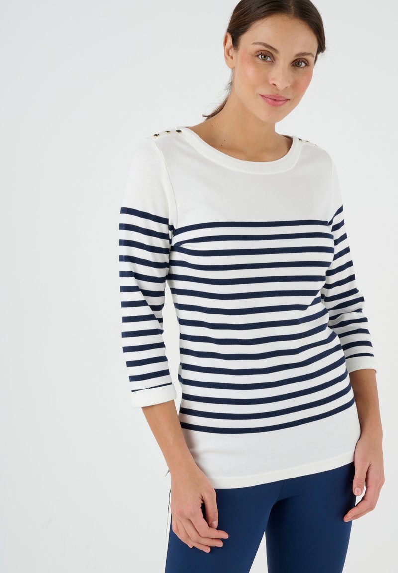 Weiß und marineblau gestreiftes Langarmshirt mit Rundhalsausschnitt und dekorativen goldenen Knöpfen an der Schulter. Aus weichem Baumwollmischmaterial.