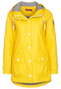 Chaqueta impermeable amarilla con capucha, botones a presión blancos, dos bolsillos frontales y un forro a rayas. Presenta cordones y un parche de la marca.