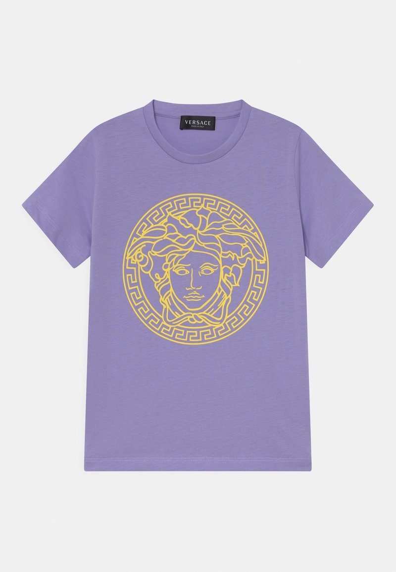 Lilla kortærmet t-shirt med rund hals og stort gult Medusa-hoved design, indrammet af et græsk nøglemønster på forsiden.