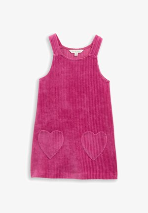 Robe en velours côtelé rose avec de larges bretelles et deux poches en forme de cœur. Le tissu texturé présente des cannelures verticales. Encolure ronde.
