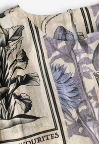 Floral patterned fabric in beige and lavender with black outlines, featuring a V-neck design and a slit at the back.