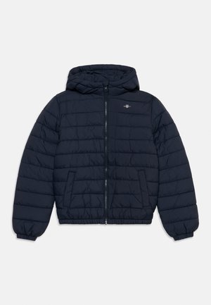 Giacca trapuntata blu navy con cappuccio, zip frontale, due tasche laterali, polsini elastici e piccolo logo sul petto.