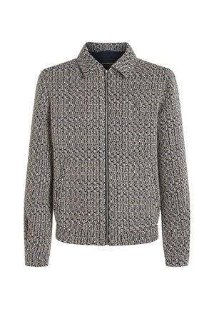 Kövesdzéses dzseki textúrált szőtt anyagból, sötétkék és bézs színekben. Jakabja és hosszú ujjai vannak, enyhe fényével és struktúrált illeszkedésével.