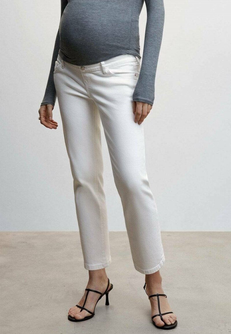 Jeans blancos de pierna recta hechos de denim con una textura suave, combinados con una camiseta gris de manga larga y sandalias negras de tiras.