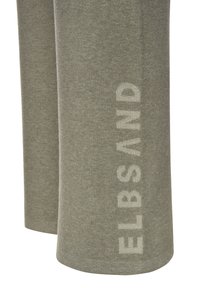 Olivgrüne Fleece-Hosen mit weicher Textur, die ein auffälliges, in hellbeige bedrucktes Logo entlang des linken Beins aufweisen.