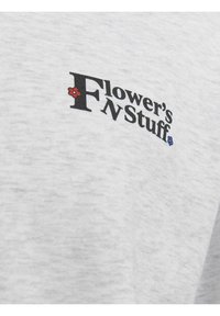 T-shirt en coton gris avec le texte noir "Flower's FnStuff" agrémenté d'accents floraux rouges et bleus. Texture douce ; design décontracté.