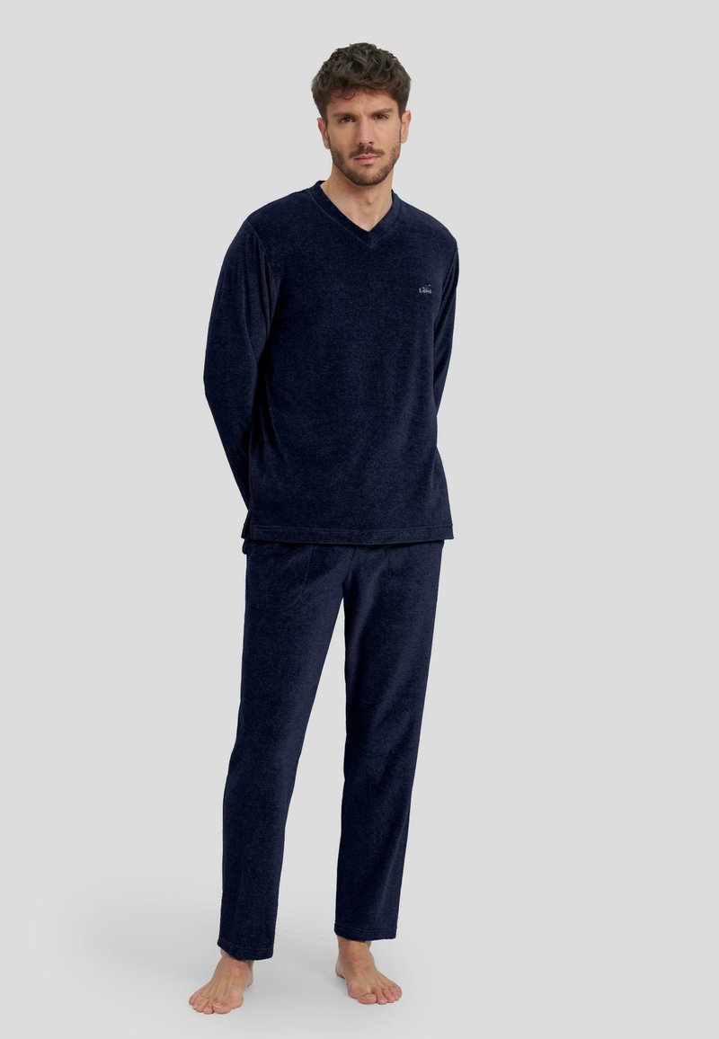 Conjunto de loungewear en color azul marino que incluye una camiseta de manga larga con cuello en V y pantalones a juego, fabricado en un tejido suave y texturizado con un corte holgado.