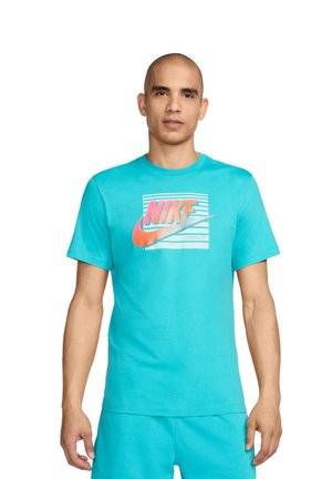 Camiseta de algodón turquesa con un logo de Nike en degradado, mangas cortas, cuello redondo y un diseño de corte relajado.