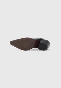 High-heeled shoe with a black synthetic upper, pointed toe, and textured brown outsole. Features a rounded heel and minimal hardware accents.