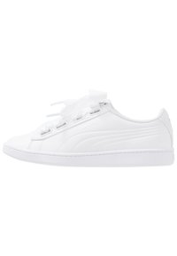 Scarpe da ginnastica bianche con tomaia in pelle liscia, dotate di chiusura con lacci piatti, un logo discreto sul lato e una suola in gomma testurizzata.