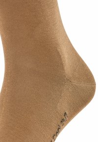 Braune Baumwollsocke mit einer glatten, gerippten Textur und einer verstärkten Ferse, mit einem kleinen aufgedruckten Logo in der Nähe des Zehenbereichs.