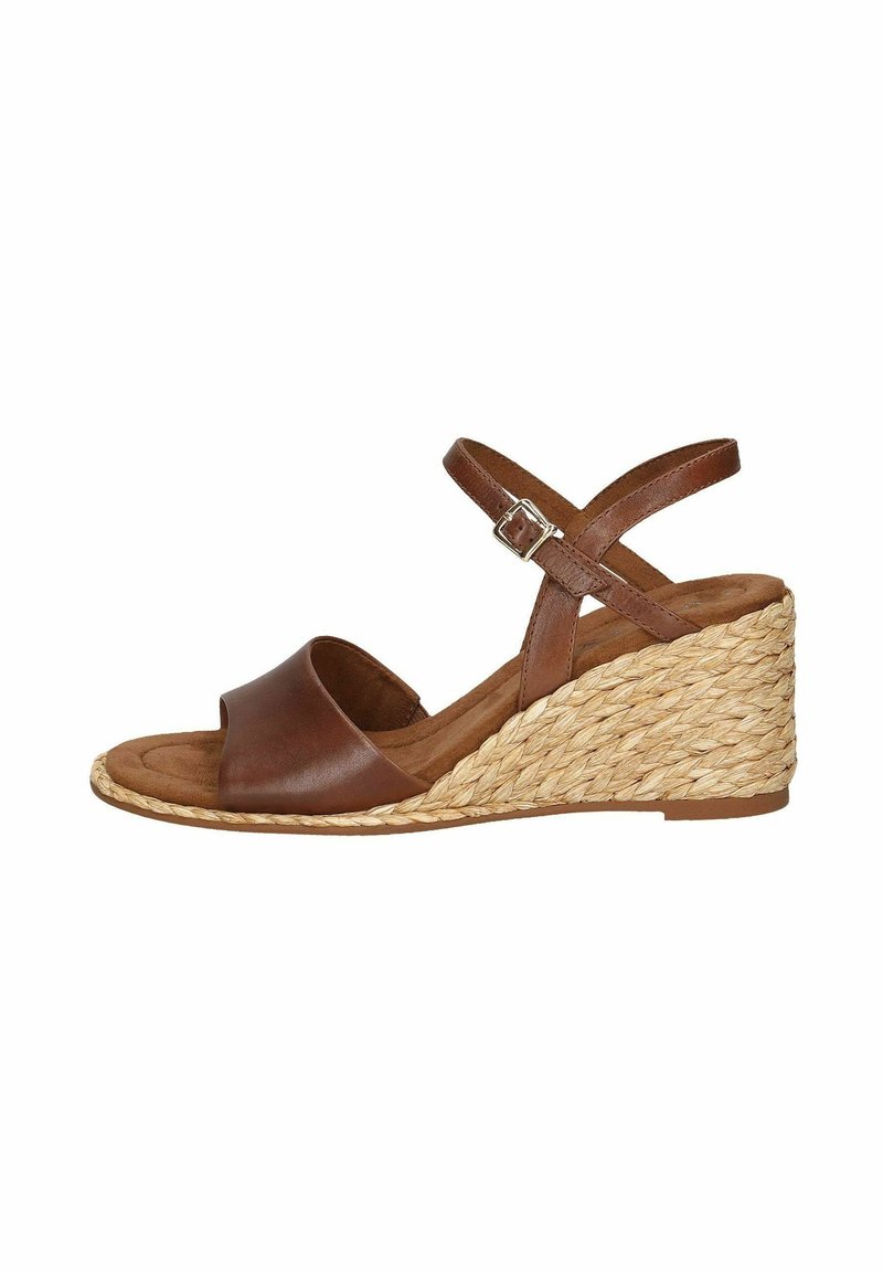 Sandale compensée en cuir marron avec bride à la cheville et boucle, présentant un talon compensé en paille tressée et un design à bout ouvert.