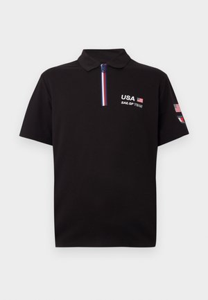 Black polo shirt with a zip collar. Features embroidered "USA" and "SAIL GP TEAM" logos. Includes red, white, and blue accents on the collar.