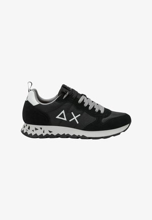 Zwart en grijs sneaker met suede en mesh, met een witte zool en details in een driehoekig patroon, en metalen ogen voor de veters.