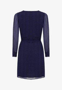 Vestido azul marino con mangas largas de tul, textura con estampado, cintura ajustada y un dobladillo sutil. Presenta una cinta en la parte posterior para un ajuste ajustable.
