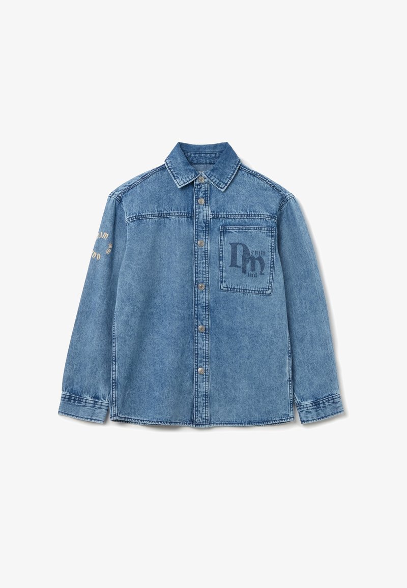 Camicia di jeans di colore azzurro chiaro con chiusura a bottoni, colletto a punta e taschino sul petto. Presenta testo stampato in blu scuro con accenti beige.