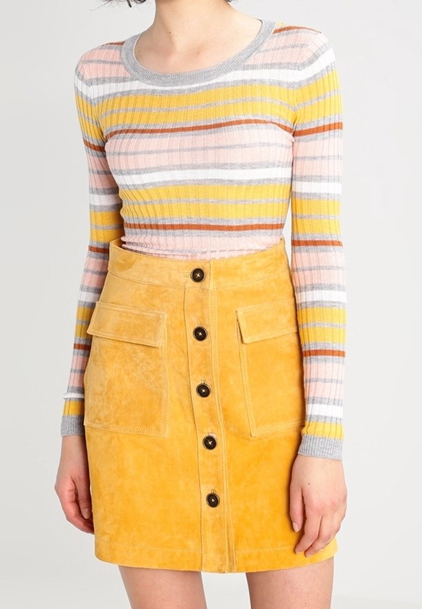 Gestreiftes Strickoberteil mit langen Ärmeln in Rosa, Gelb und Grau, kombiniert mit einem senfgelben Wildlederrock mit Knopfverschluss und zwei Taschen.