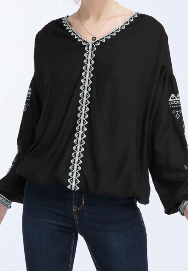 Blusa nera con scollatura a V, caratterizzata da intricato ricamo turchese lungo il davanti e le maniche. Il tessuto sembra leggero e fluido.