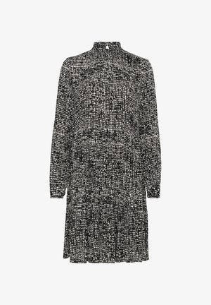 Zwart-wit gestippelde jurk met lange mouwen, een hoge halslijn en een geplooide taille. De stof lijkt lichtgewicht en gestructureerd.