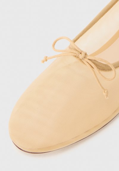Beige ballet flat shoe made of smooth fabric, rounded toe, with a delicate bow on the front and a soft interior lining.