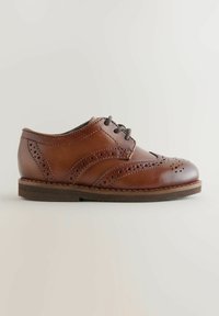 Chaussure en cuir marron à lacets avec des détails perforés, un bout rond et une semelle foncée contrastante. Texture lisse avec des accents de design subtils.