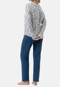 Lätt långärmad topp med ett blommigt mönster i blått och beige, matchad med enfärgade marinblå byxor. Mjuk tygkänsla med avslappnad passform.