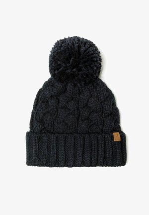 Bonnet en tricot sombre avec un grand pompon sur le dessus, présentant un motif de câbles texturé et un poignet côtelé. Inclut une petite étiquette en cuir avec un logo.