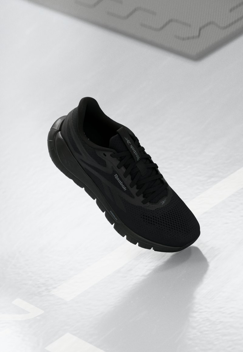 Black running shoe with a mesh upper and textured sole. Features laces, a padded collar, and branding on the sides. Lightweight design.