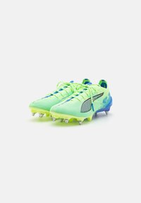 Le scarpe da calcio verde lime e blu presentano una tomaia in mesh testurizzato, tacchetti moldati e lacci a contrasto con un logo laterale prominente.