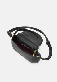 Sac à main en cuir noir avec une finition texturée, accents en métal doré, et un dessus ouvert révélant un intérieur bordeaux. Sangle réglable incluse.