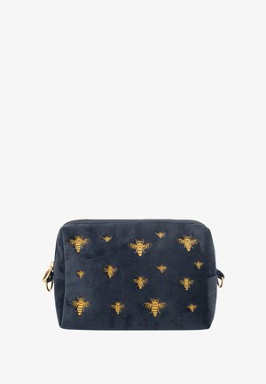 Bolsa rectangular azul marino con cremallera dorada y abejas bordadas en dorado de varios tamaños en el frente.