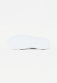Sole di sneaker bianca con logo "GUESS" in rilievo, bordatura testurizzata, forma arrotondata e finitura liscia, progettata per la trazione e il comfort.