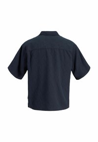 Chemise bleu marine à manches courtes avec un tissu texturé, ourlet droit et col, vue de dos sur fond blanc.