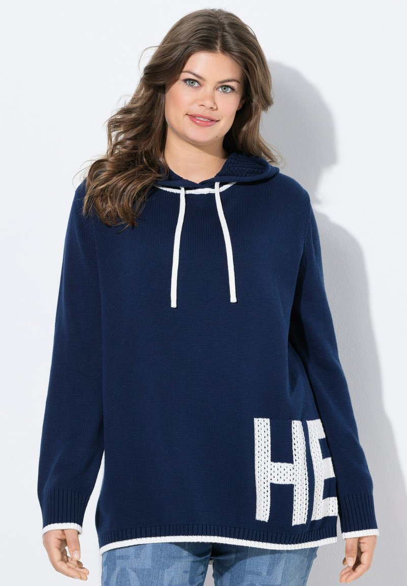 Hoodie en tricot bleu marine avec des cordons blancs, comportant un panneau en maille avec le texte "HE" sur le bas à gauche et des poignet en bords côtes.