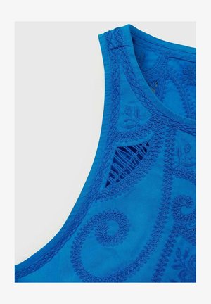 Haut sans manches bleu avec une broderie tonale complexe comprenant des motifs de tourbillons et de feuilles ; tissu texturé avec un détail découpé pour la respirabilité.