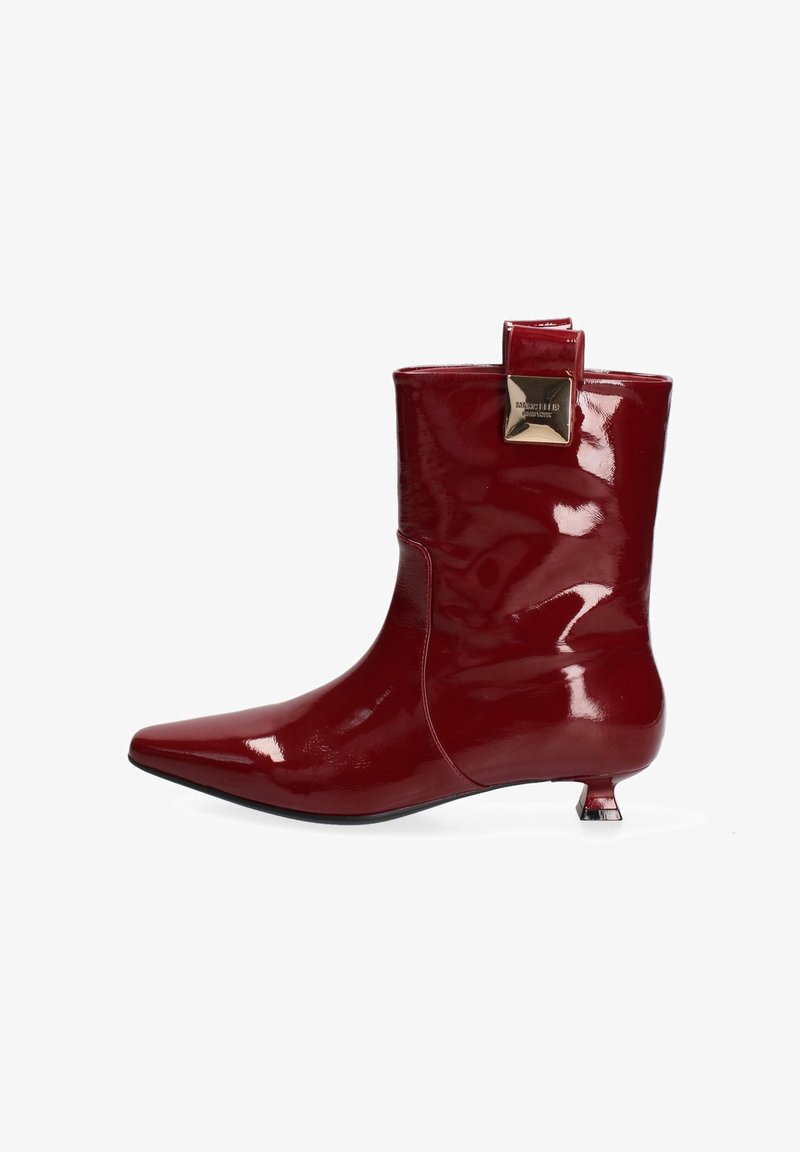 Stivaletti alla caviglia in pelle verniciata rossa con punta affilata, tacco di media altezza e un accento quadrato decorativo sul retro. Finitura lucida.