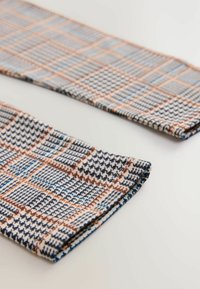 Gewebter Stoff mit einem blau-braun-weißen Schottenmuster. Weiche Textur mit kontrastierenden Farben im gesamten Design.