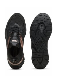 Scarpe sportive nere con tomaia in mesh testurizzato, collo imbottito e suola in gomma. Presentano un accento metallico e un motivo di battistrada prominente.