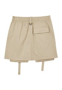 Jupe beige avec une taille élastique, fermeture à boutons sur le devant et une poche sur le côté. Dispose de deux bretelles réglables au bas de l'ourlet.