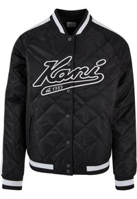 Black quilted bomber jacket with white striped collar and cuffs, features a large embroidered "Kani" logo and snap button closure.