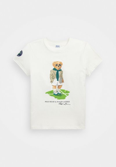 T-shirt branca de algodão com uma ilustração texturizada de um urso com óculos de sol, vestido com um blazer e calções, segurando uma raquete de ténis.