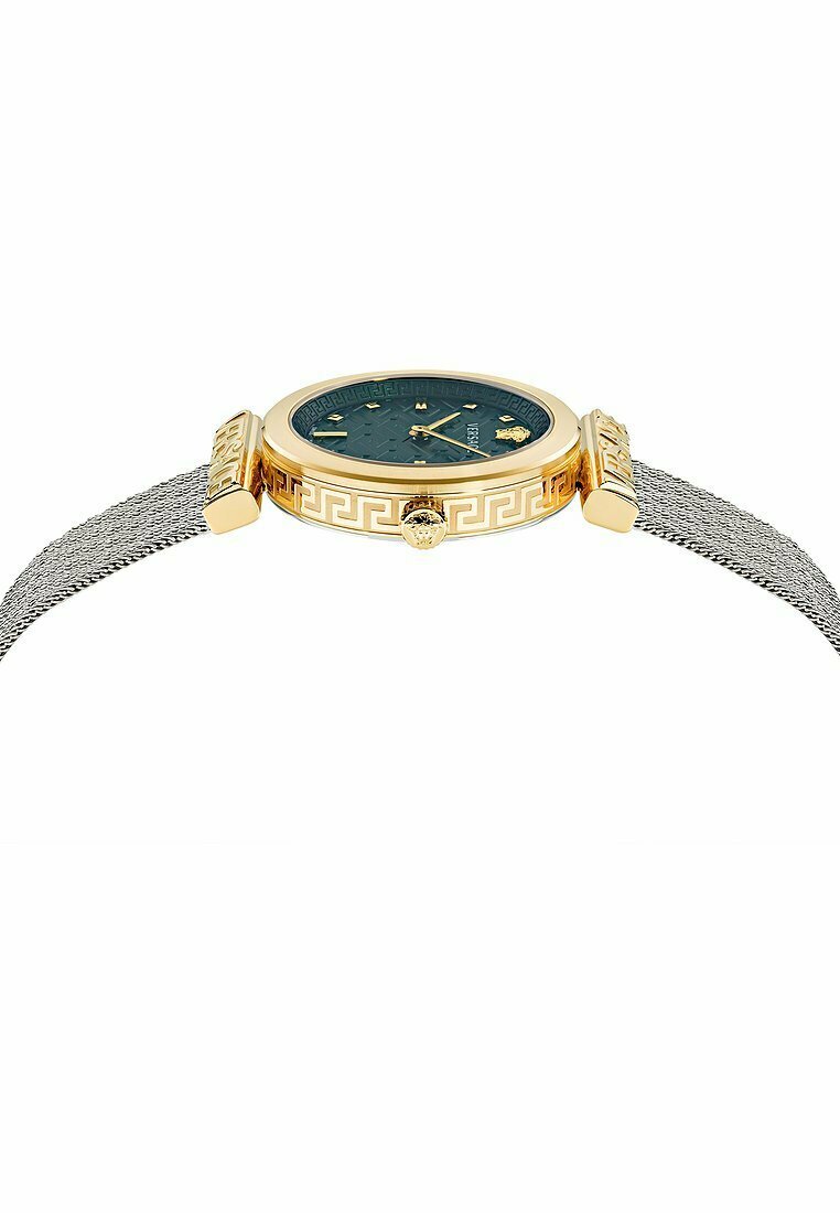 Reloj de tono dorado con una esfera verde texturada, forma redonda, correa de malla plateada y detalle de llave griega en la caja junto con una corona prominente.