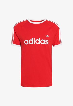 Czerwona bawełniana koszulka z białymi wykończeniami i trzema białymi paskami na rękawach. Z przodu duże białe logo "adidas". Standardowy krój.