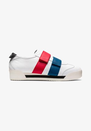 Baskets blanches avec larges brides Velcro rouges et bleues, languette de talon noire, et semelle blanche avec détail de bande noire.
