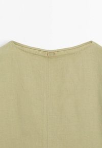 Tissu en coton vert olive avec un col rond ; présente une texture lisse et une couture discrète le long de la couture arrière.