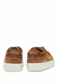 Ruske kengät valmistettu mokkanahasta, joissa on sileä päällinen, valkoinen kumipohja ja minimalistinen muotoilu. Takana on pieni brändilogo.