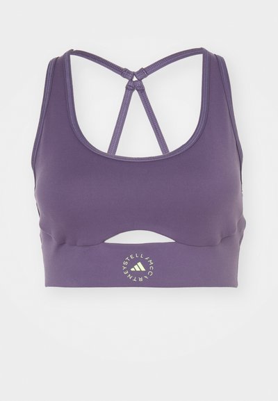 Violeta sporta krūšturis, izgatavots no elastīga materiāla, ar apaļu kakla izgriezumu, ar izgriezumiem dizainā un krusteniskām siksnām mugurā. Logo priekšpusē.