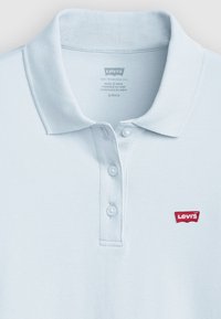 Polo bleu clair en tissu texturé, avec une patte de boutonnage à trois boutons et un petit logo rouge Levi's sur la poitrine gauche.