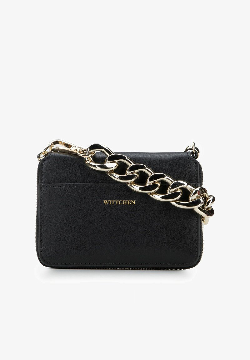 Borsa in pelle nera con tracolla in catena dorata, dotata di chiusura a zip e logo impresso. Texture liscia con un design minimalista.