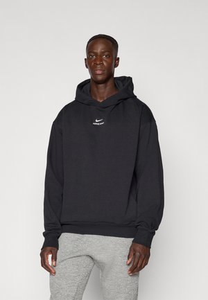Black Nike Pro hoodie featuring a front logo, long sleeves, and a drawstring hood. Soft fabric with a relaxed fit and ribbed cuffs.